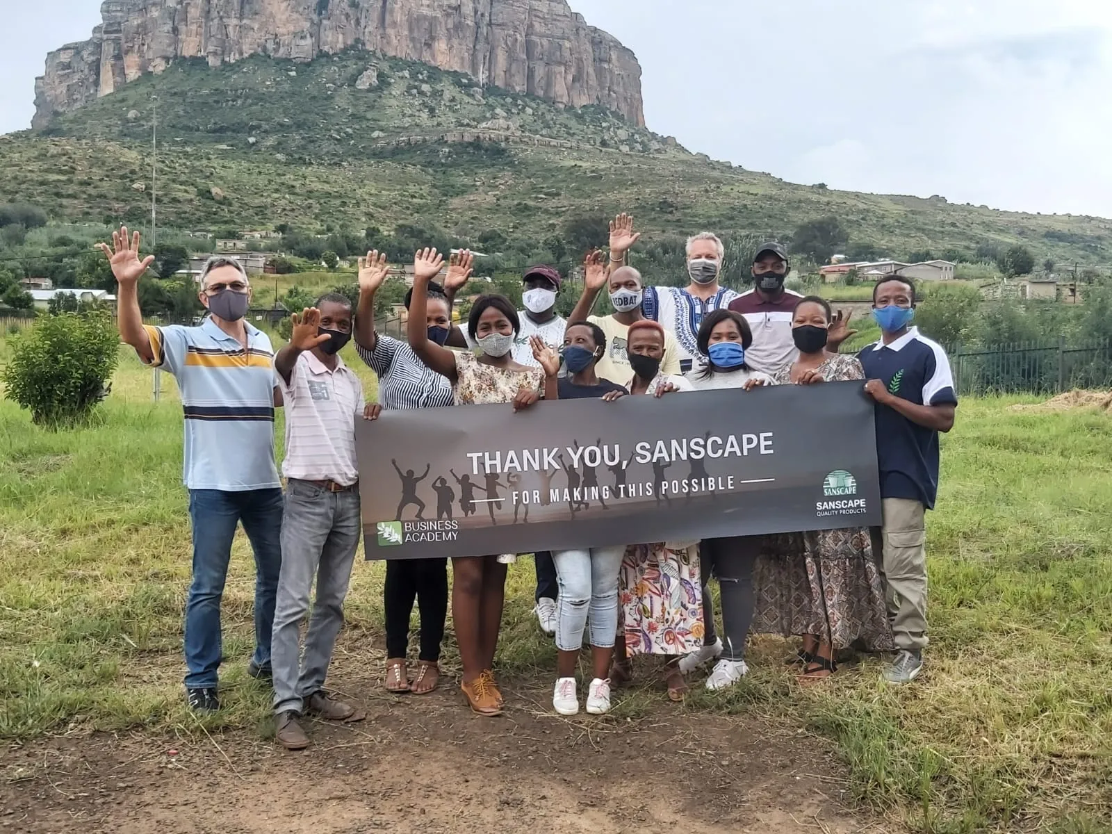 Community members holding a 'Thank you, Sanscape' banner
